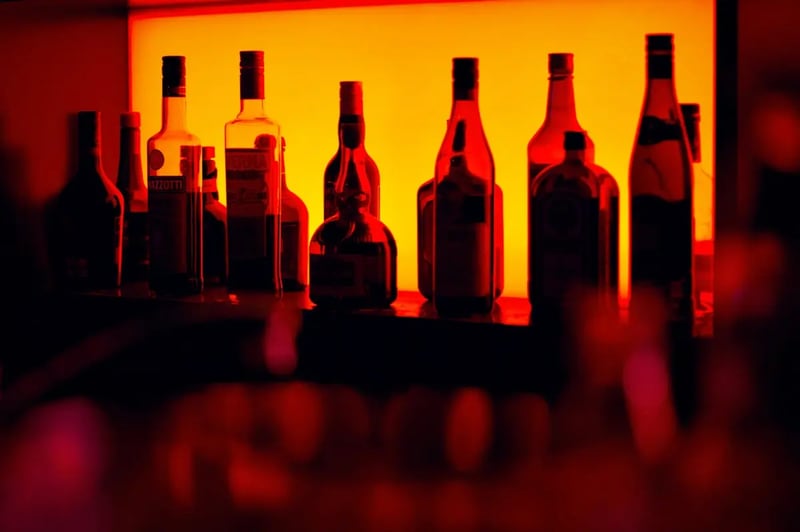 Assorted glass bottles illuminated in a bar laboratory setting