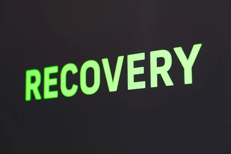 Close-up of a neon sign that reads the word recovery